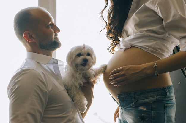 Het paar in liefde zwanger ligt in bed knuffelend, wachtend op baby