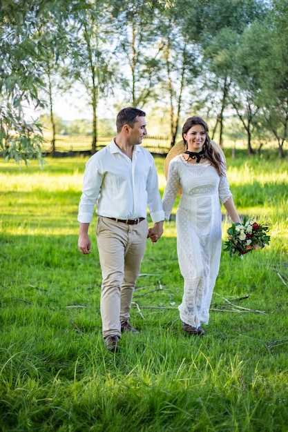 Het paar loopt over het veld Ze houden de hans vast De sluier vervliegt In de handen van een boeket