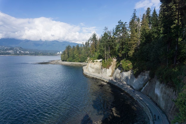 Het pad langs de zeedijk aan het water in Stanley Park Vancouver