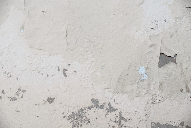 Het patroon van een betonnen witte muur met gebarsten verf. Grunge textuur achtergrond