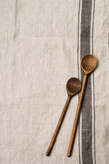 Het patroon van grijze stof met bruine streep en twee houten oude vintage lepels