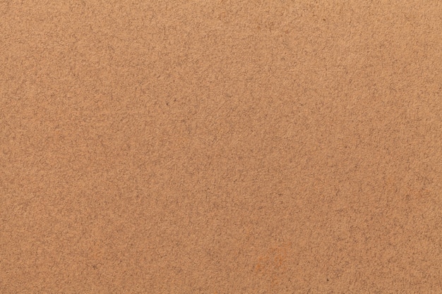 Het patroon van oude licht bruin papier. Structuur van een mat dicht kartonnen behang. Zand voelde achtergrond.