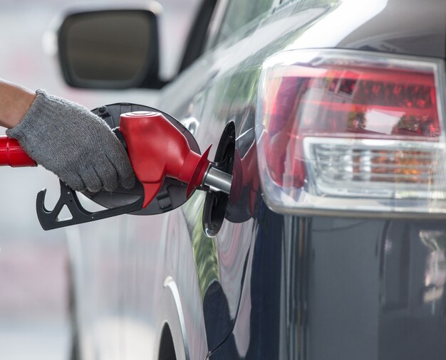 het pistool is de auto aan het tanken