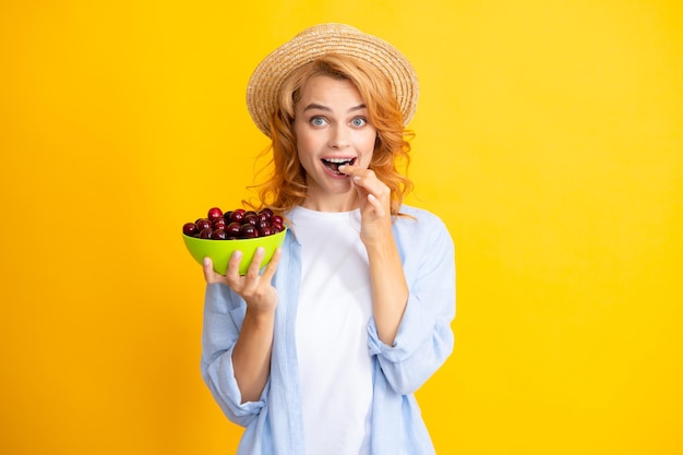 Het plukken van het eten van kersen fruit Jonge vrouw eet zoete kersen Portret van een mooi meisje met kers op gele achtergrond Zomerfruit plukseizoen Natuurlijke vitamines