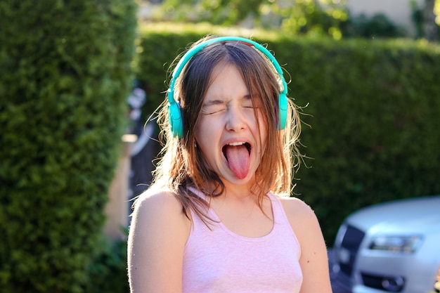 Het portret van de close-up van grappig preteen meisje met draadloze hoofdtelefoons op hoofd