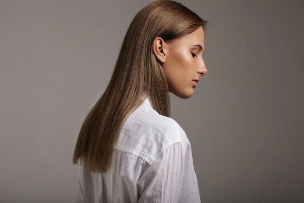 Het portret van de close-upvrouw met ideale glanzende huid en steil gezond haar