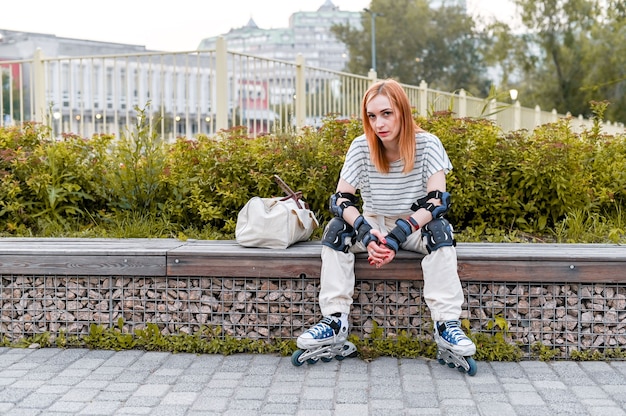 Het portret van de volledige lengte van sportieve vrouw in rolschaatsen op straat