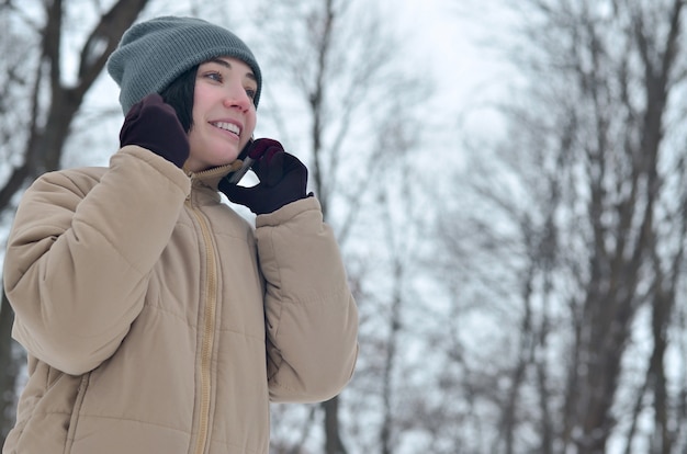 Het portret van de winter van jong meisje met smartphone