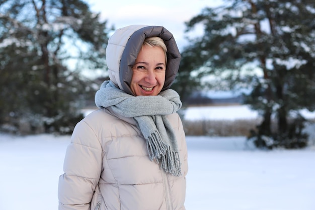 Het portret van een gelukkige, mooie oudere senior gepensioneerde vrouw in leeftijd speelt plezier met sneeuw