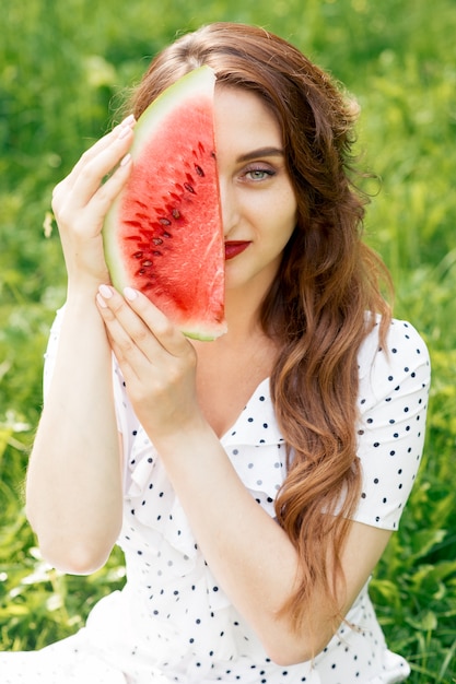 Het portret van een glimlachend meisje houdt watermeloenplak