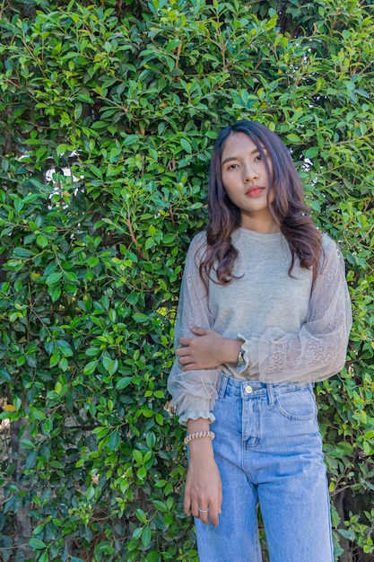 Het portret van een mooie vrouw stelt voor fotografie met groene boom