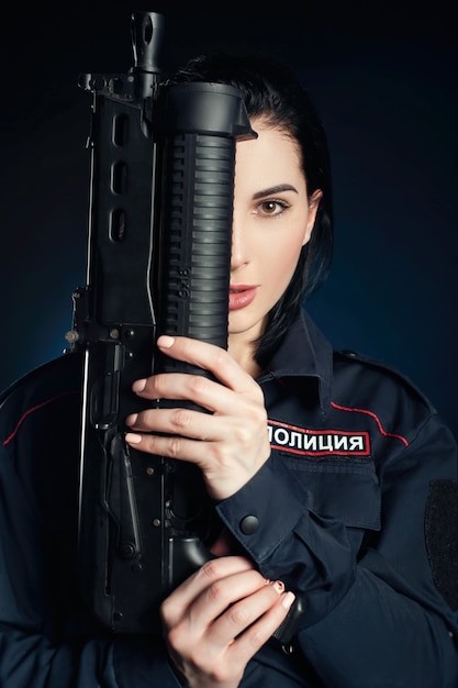 Het portret van een vrouw in een Russisch politie-uniform met een geweer Engelse vertaling politie
