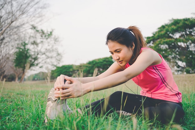 Het portret van gezonde vrouwen warmt oefeningen vóór het lopen van jogging op