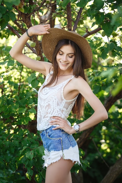 Het portret van het de Zomermeisje in Groenen. Jonge mooie donkerharige vrouw geniet van de koelte van de zomertuin.