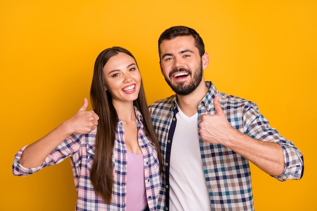 Het portret van het positieve vrolijke team van de echtpaarpromotor keurt advertenties goed