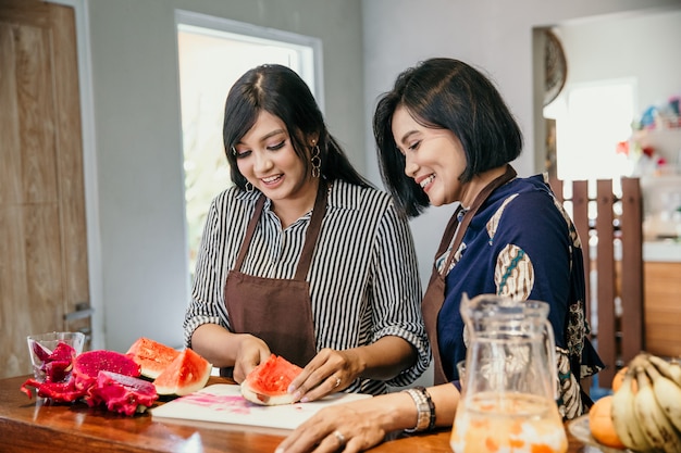 Het portret van twee vrouwen snijdt een draakfruit