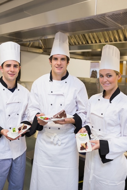 Het presenteren van cakes van drie gelukkige Chef-kok