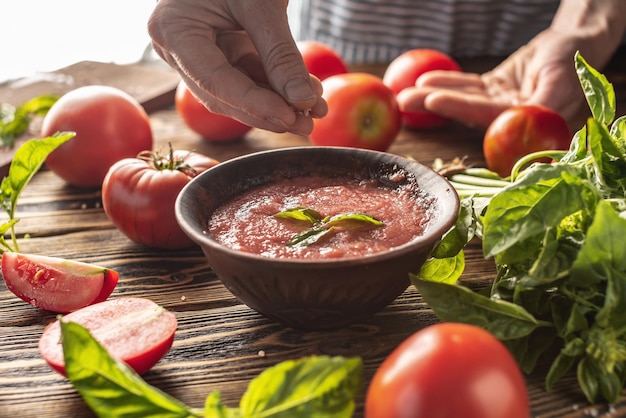 Het proces van het koken van een traditionele Italiaanse saus van tomaten en basilicum van natuurlijke rijpe groenten Rustieke stijl