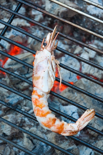 Het proces van het koken van langoustine op de grill op de achtergrond van hete kolen