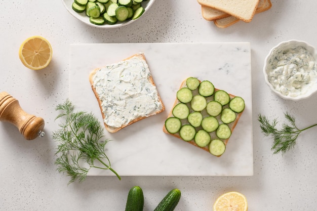 Het proces van het koken van traditionele engelse theesandwiches met komkommer en roomkaas voor het ontbijt