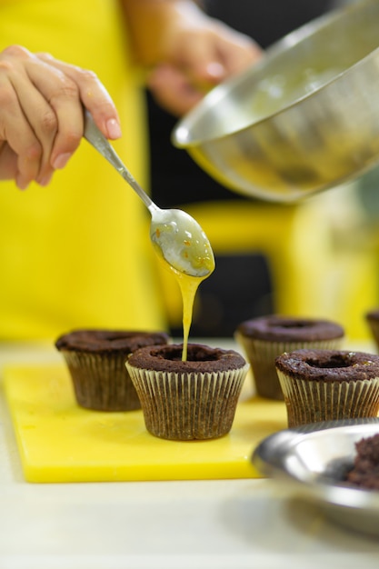 Het proces van het maken van chocolade cupcakes met zoete room. Taarten maken door professionele banketbakkers