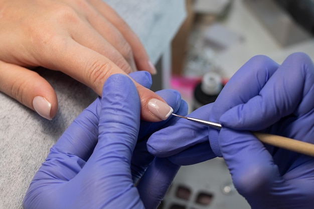 Het proces van het maken van een Franse manicure Manicure tekent een witte streep op de nagel Gellak