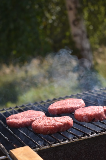 Het proces van het maken van hamburgers op de grill in de tuin