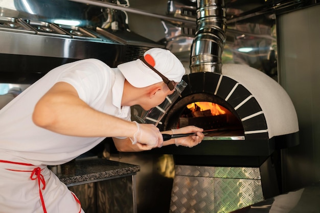 Het proces van het maken van pizza Italiaanse pizza in houtkachel Italiaanse pizza wordt gekookt in een houtgestookte oven