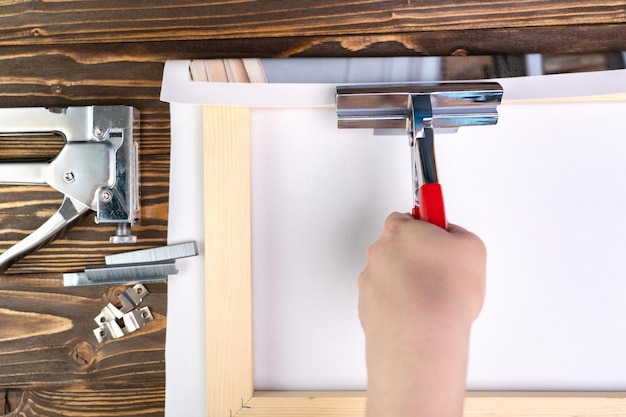 Het proces van het oprekken van een synthetisch canvas op een brancard. Foto's op canvas printen en schilderijen maken