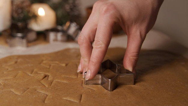 Het proces van het versieren van kerstkoekjes is in beweging Close-up van een vrouw die een zelfgemaakte peperkoek versiert