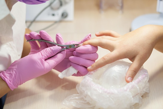 Het proces van manicure Roze handschoenen steriel instrument Vrouwelijke handenxA