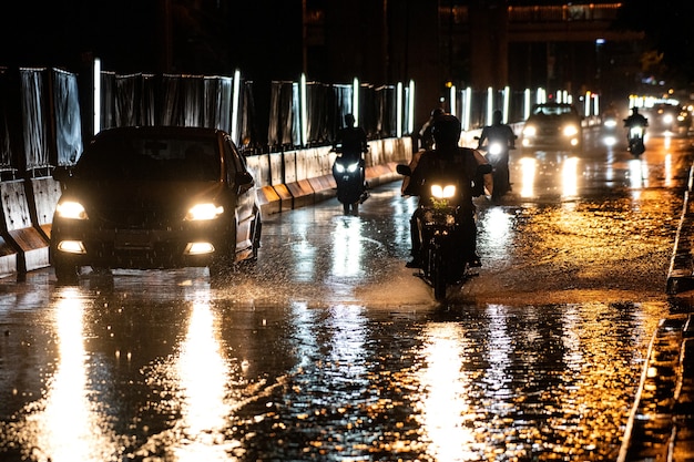 Het regent op de stad op straten met auto's en motorfietsen.