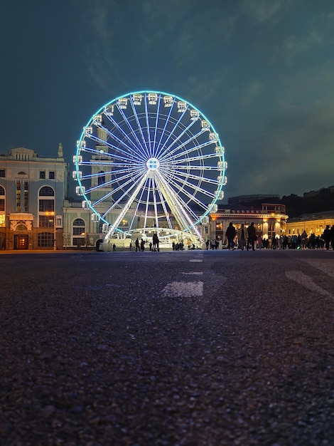 Het reuzenrad op het stadsplein wordt verlicht met elektrische lampen. Lage opnamehoek