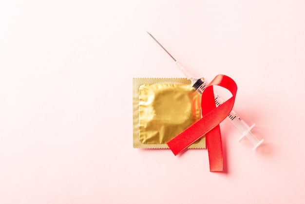 Het rode symbool van het booglint HIV, AIDS-kankervoorlichting, condoom en spuit
