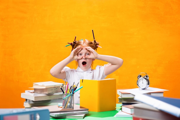 Het roodharige tienermeisje met veel boeken thuis. Studio opname