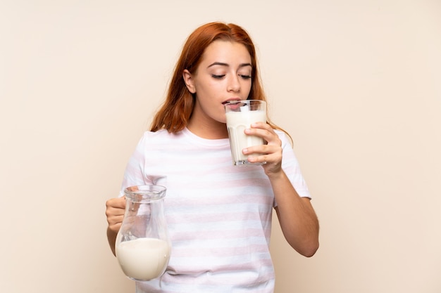 Het roodharigemeisje dat van de tiener een glas melk houdt