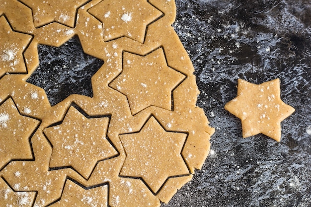 Het ruwe deeg van de Kerstmis eigengemaakte peperkoek uitgerold op donkere lijst