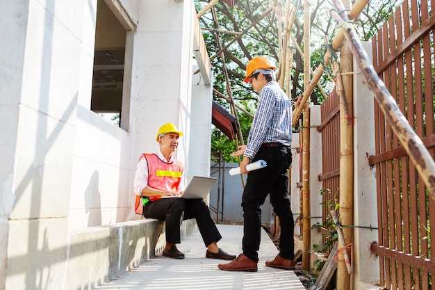 Het samenwerken van architectenieur die mensen bespreken bij woningbouw bouwwerf