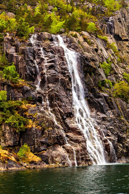 Het schilderachtige landschap: waterval, rotsen en zee