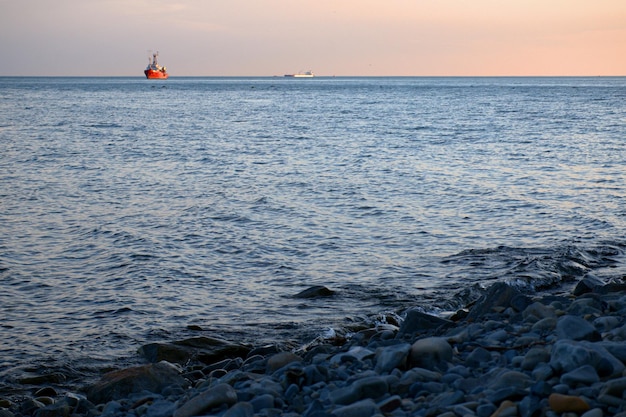 Het schip tegen de achtergrond van roze wolken bij zonsondergang vaart op de golven Zomeravond Prachtig sprookjeslandschap Zwarte Zee Rusland