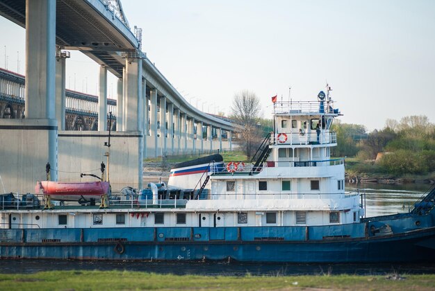 Het schip vaart bij zonsondergang onder de brug door