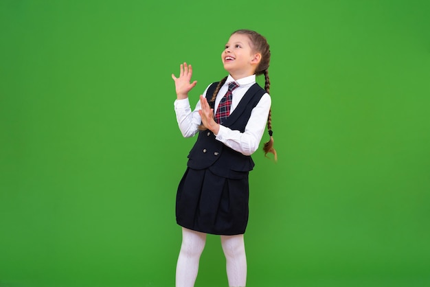 Het schoolmeisje kijkt blij weg en lacht Schooluniformen voor studenten