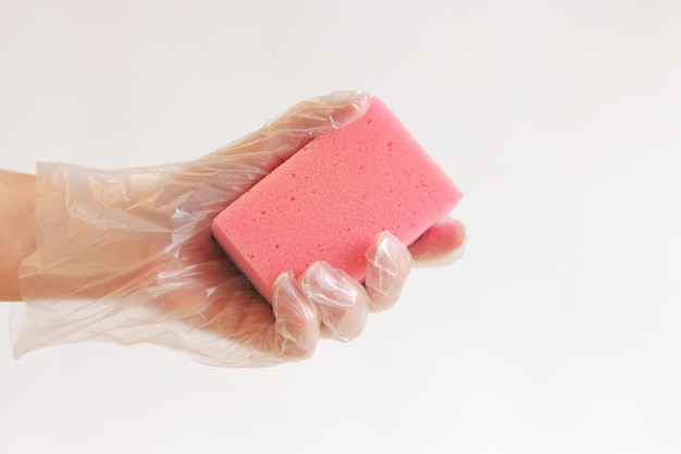 Het schoonmaken van de kamer spons in hand close-up Vrouwelijke hand in een handschoen met een spons