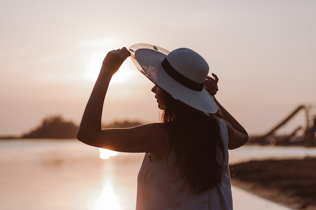 Het silhouet van een vrouw bij zonsondergang Profiel silhouet van een jonge vrouw die de rand van een rietje vasthoudt ...