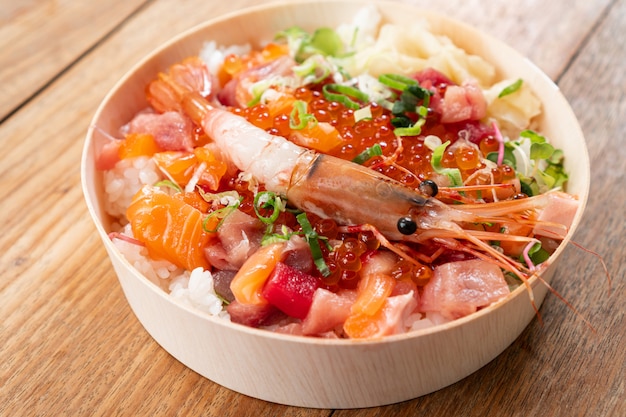 Het smakelijke en heerlijke chirashi Japanse voedsel op houten lijstachtergrond, het Gezonde Eten en eet goed Concept. Neem eten mee naar huis. Detailopname