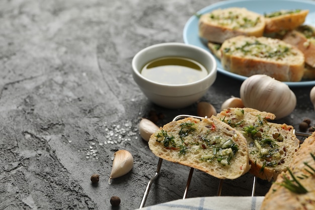 Het smakelijke knoflookbrood en de kruiden op grijs, sluiten omhoog