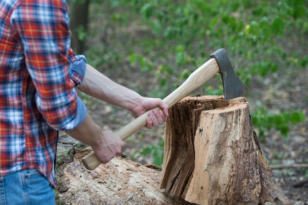 Het snijden van wat brandhout. hout hakken. houten chopper in mannelijke handen. lumbermans-apparatuur. houtkap. hout oogsten. zomer natuur.