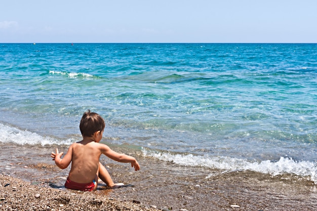 Het spelen van de jongen op het strand