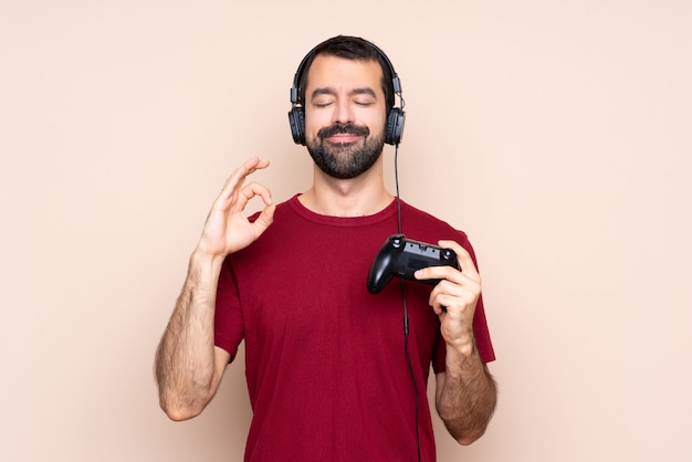 Het spelen van de mens met een videospelletjecontrolemechanisme over geïsoleerde muur in zen stelt