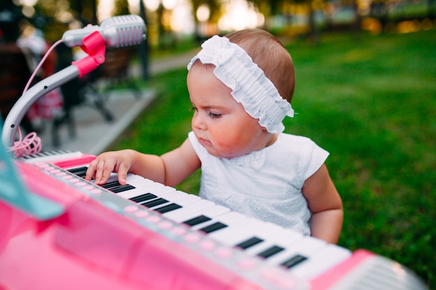 Het spelen van het meisje op een stuk speelgoed piano in het park